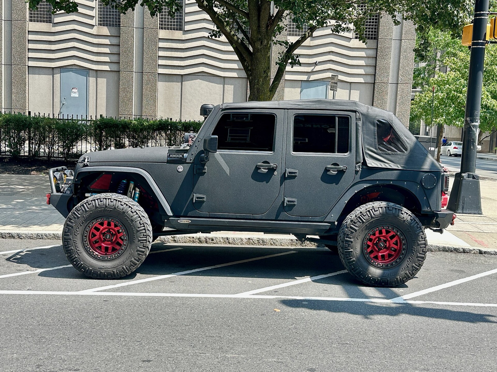 A Jeep Wrangler, the global archetype of the "we kept the ladder frame" school of off-roader design. China's 212, the Bao 5 and the Bao 8 sit in the same structural tradition: when the customer genuinely needs to leave the road, the body-on-frame is still the right baseline. (Image: Wikimedia Commons, CC BY-SA 4.0, Oleg Yunakov)